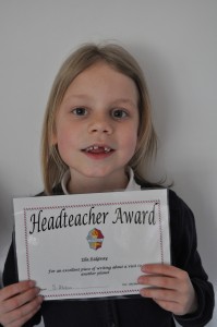 Day 22:  Ella bringing home a 'Headteacher Award' certificate for a story she had written